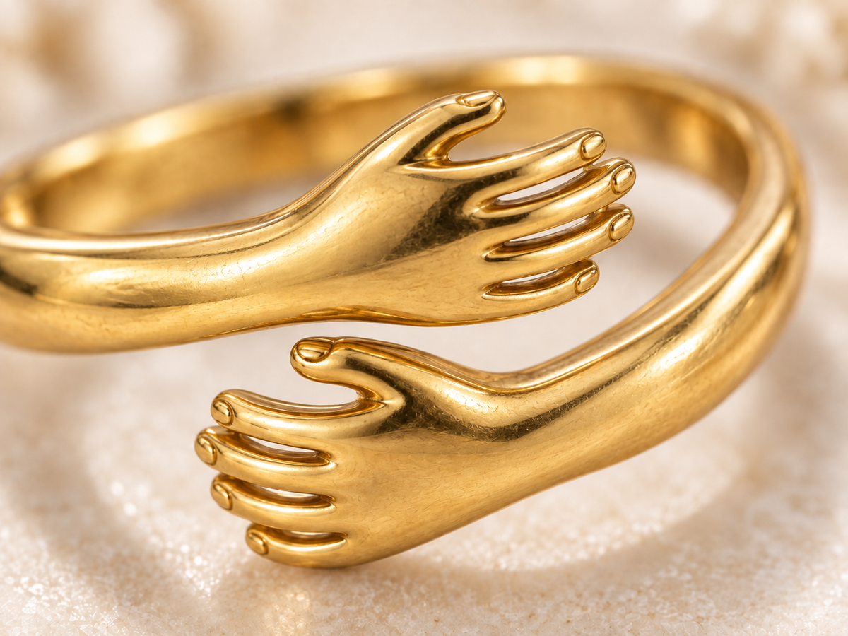 Close-up of gold Embrace Ring hands detail